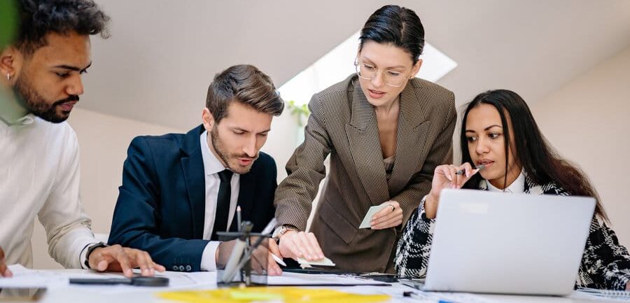 Blog Führungsstil: Ein Arbeitsteam arbeitet ermutigt an einem Projekt.